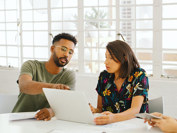 Young businesswoman and businessman using a laptop during a meeting in a modern office