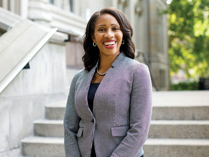 A businesswoman poses outside a large stone building