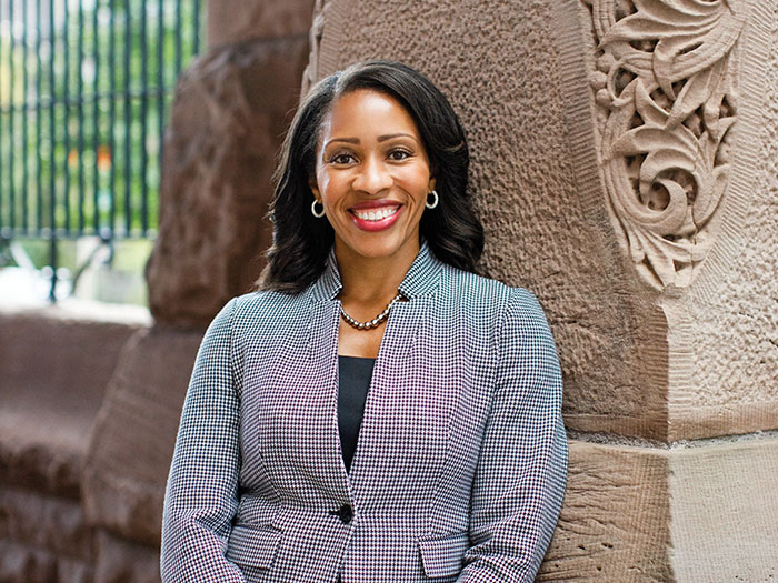 A businesswoman stands a stone carved pillar