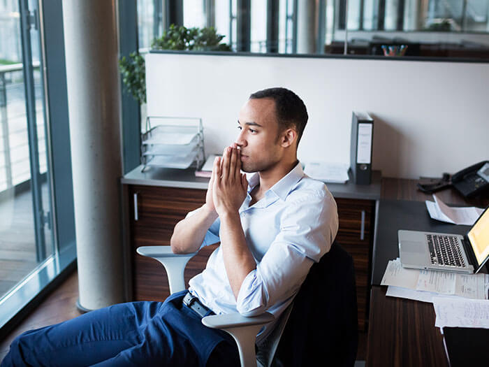 Un jeune homme est assis à son bureau