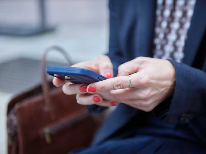 Hands are shown holding a cell phone